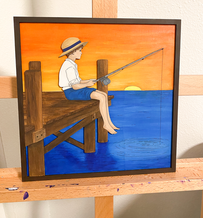 Painted layered wood fishing boy art showing child sitting on dock over blue water with yellow and orange sunset sky sitting on a painting easel