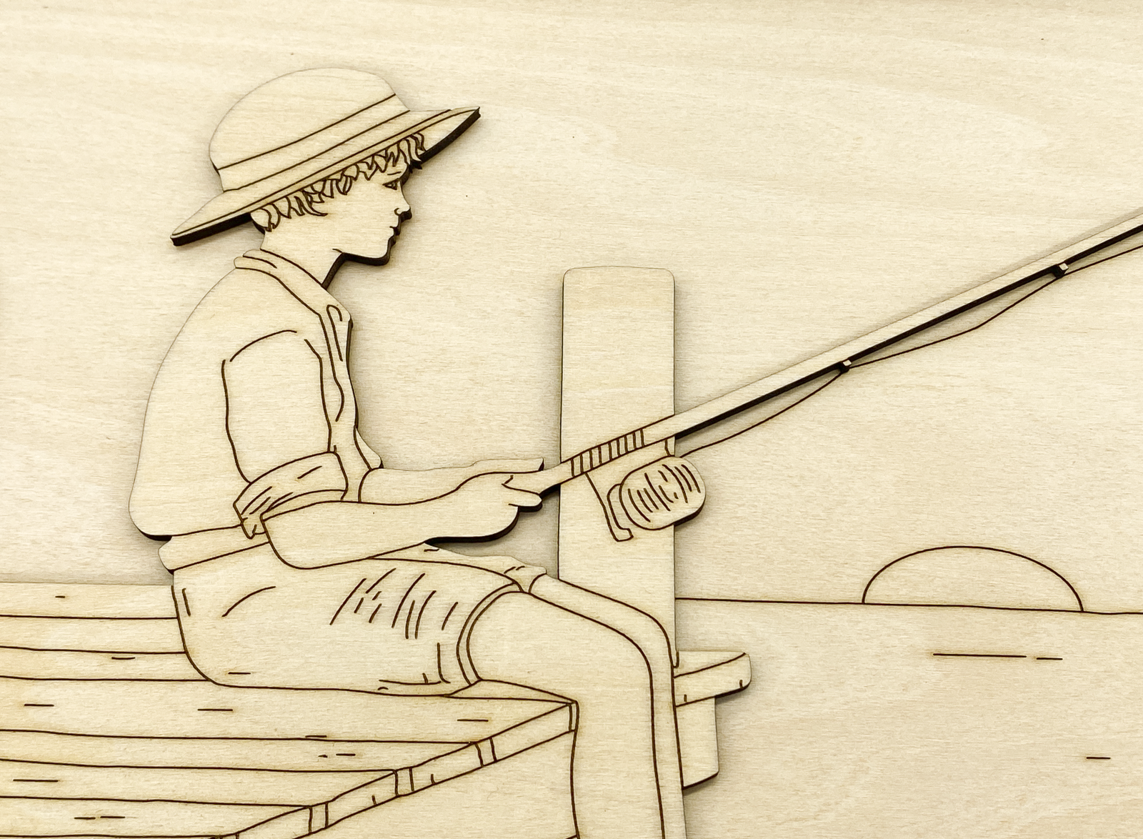 Close-up of painted fishing boy kit showing layered wood detail 