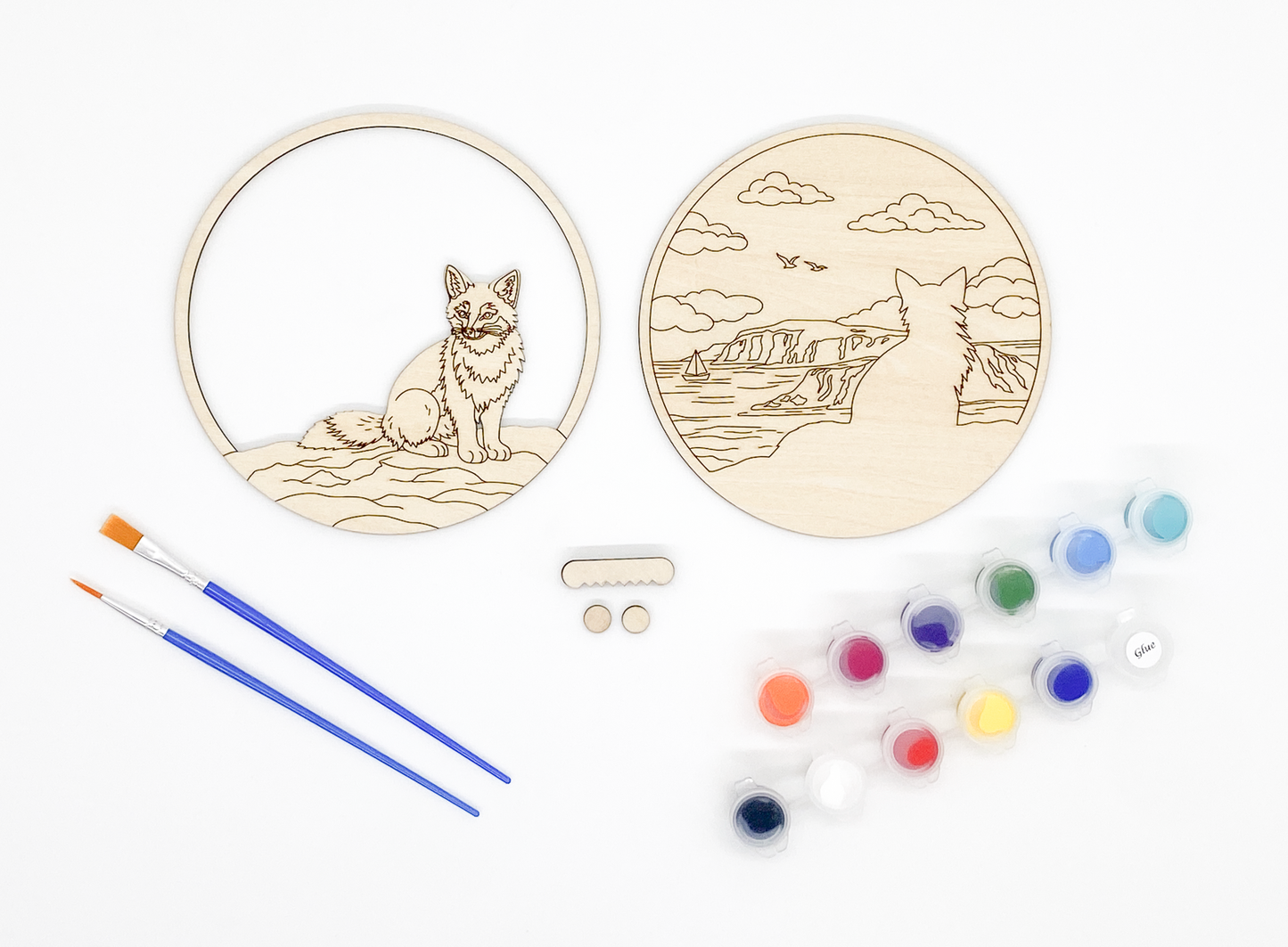 Fox DIY paint kit with unpainted layers laid flat alongside paints, brushes and hanger hardware