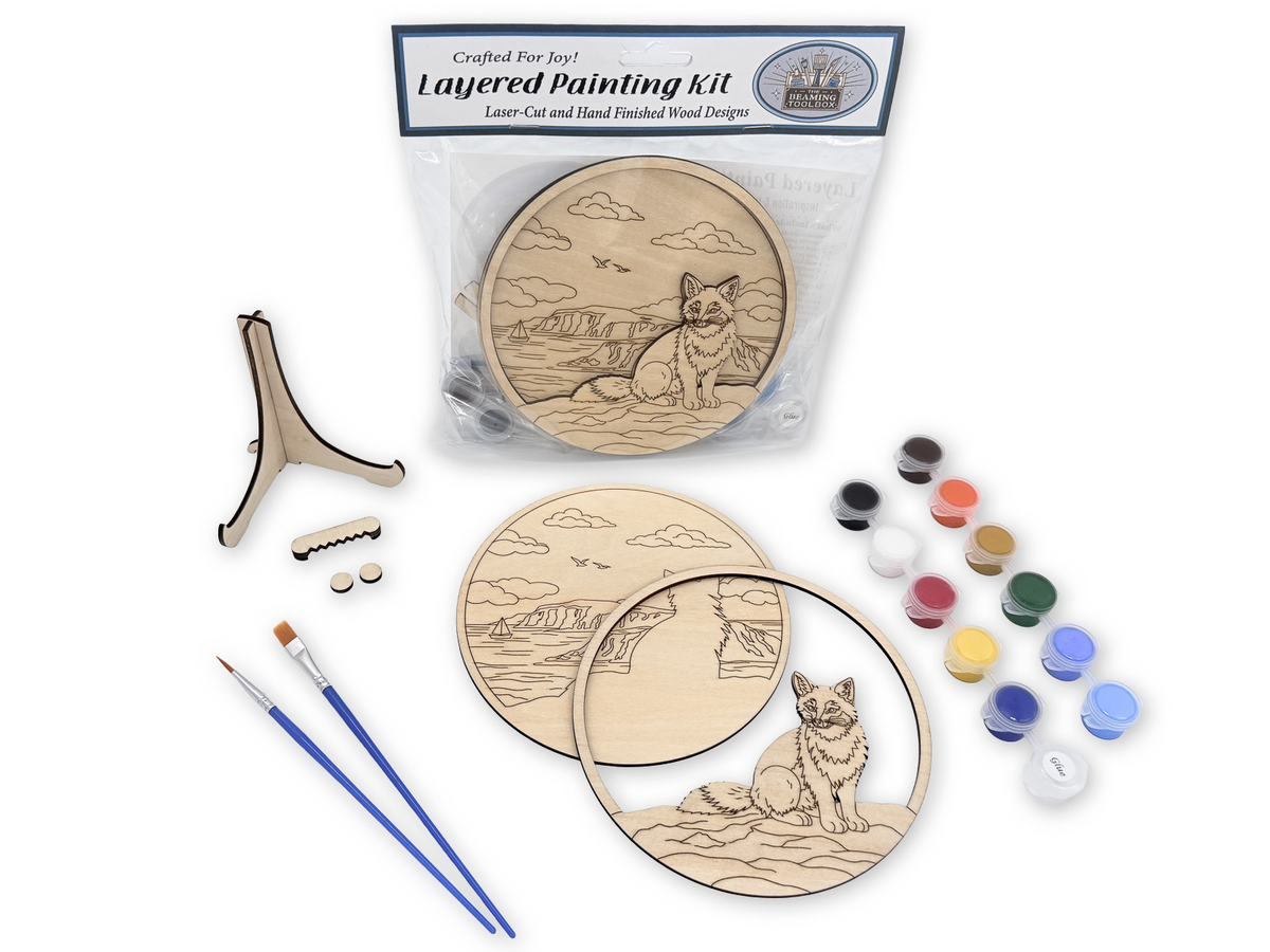 Complete Fox Coastal adult craft kit with layered wood pieces, paint pots, brushes, glue, display stand, hardware, and packaged guide.