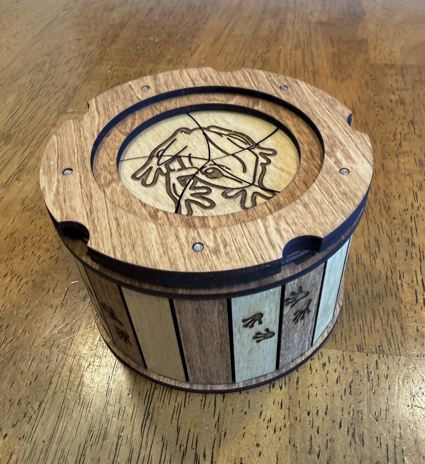 Angled view of the Frog Keepsake Box showing engraved frog lid and frog footprint details around the sides.