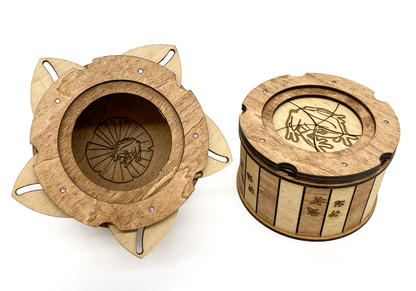 Close-up comparison of the Frog Keepsake Box opened and closed, highlighting the iris mechanism and engraved frog artwork.