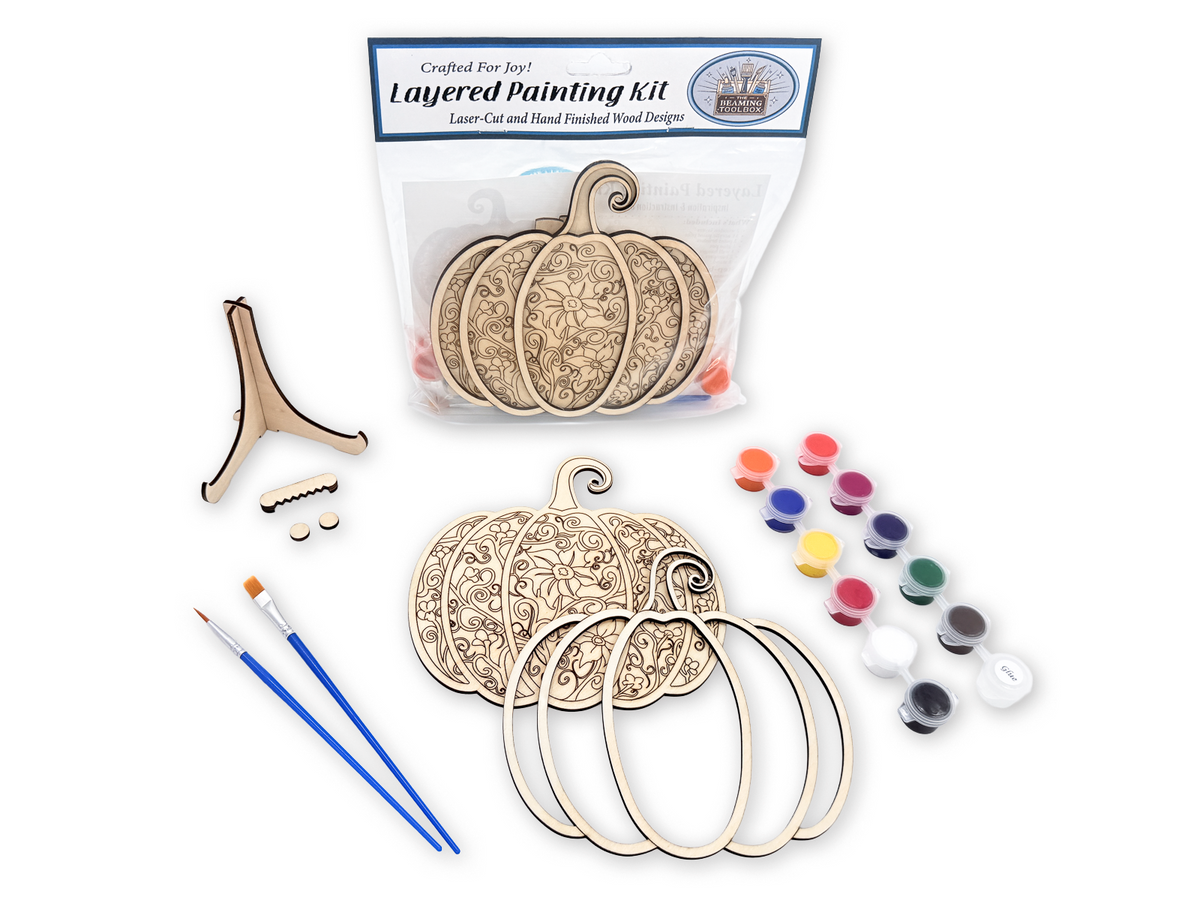 Complete Gothic Pumpkin adult craft kit with layered wood pieces, paint pots, brushes, glue, display stand, hanger hardware, and packaged guide.