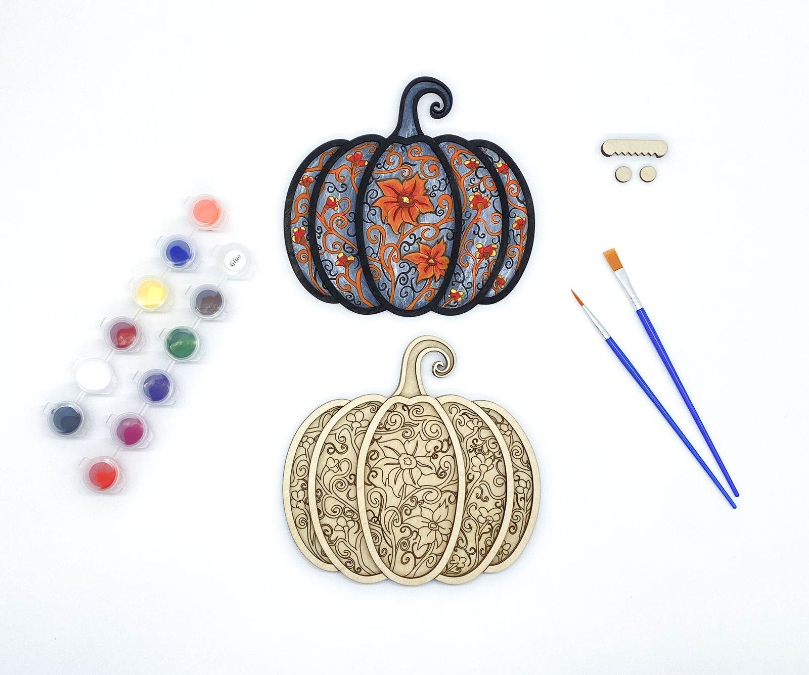 Gothic pumpkin paint kit with finished sample and stacked wood layers including paint pots and brushes
