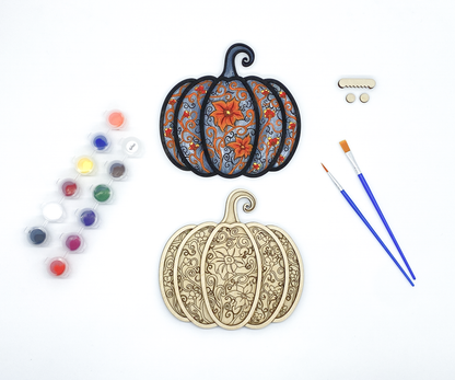 Gothic pumpkin paint kit with finished sample and stacked wood layers including paint pots and brushes