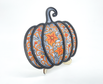 Angled view of painted gothic pumpkin wood art showing layered scrollwork detail and dimension