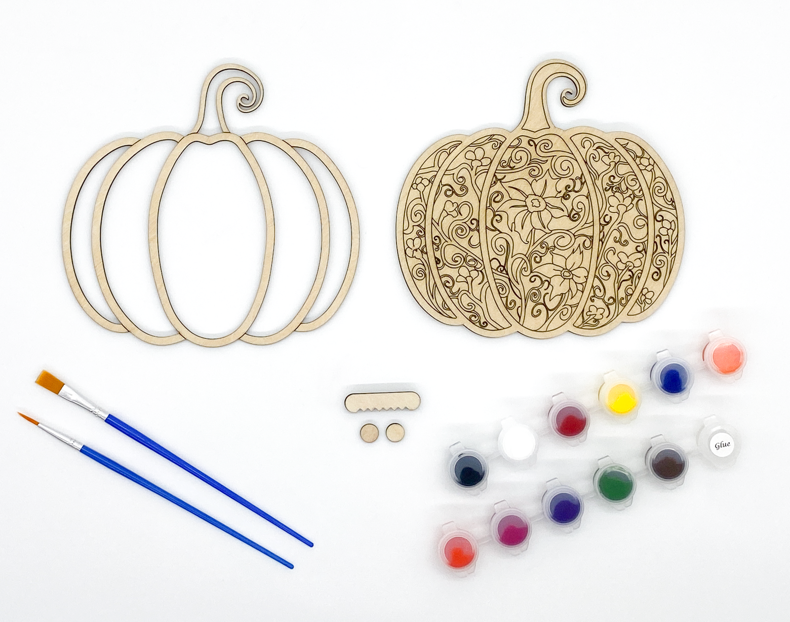 Gothic pumpkin DIY paint kit with unpainted layers laid flat alongside paints, brushes and hanging hardware
