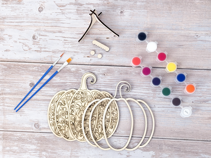 Gothic Pumpkin DIY wood painting kit with unfinished layers, paint pots, brushes, display stand, packaging, and a finished painted example.