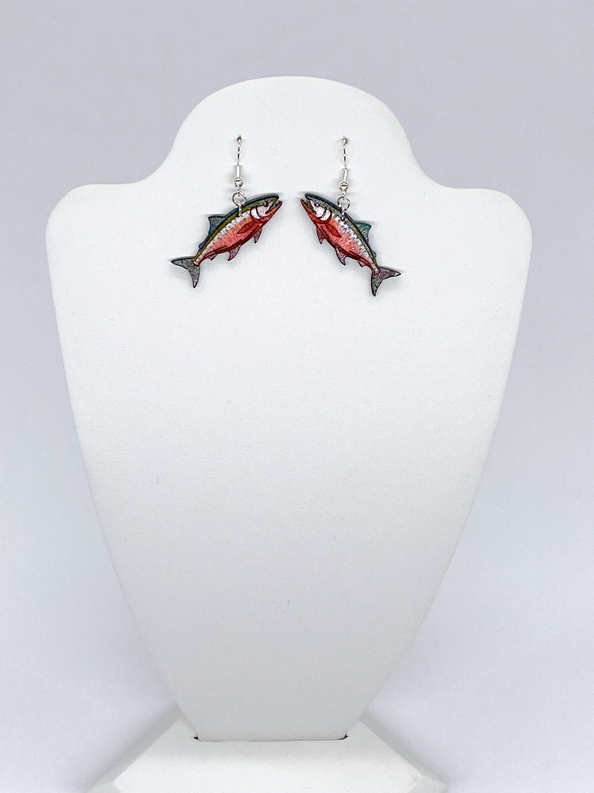 Fish-shaped earrings on a white mannequin bust against a light gray background