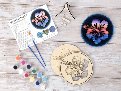 Hawaiian Hibiscus DIY wood painting kit with unfinished pieces, paint pots, brushes, instruction sheet, and finished painted example.