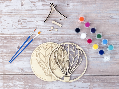 Finished Hot Air Balloon layered wood artwork painted in bright rainbow colors and displayed on a small wooden stand.