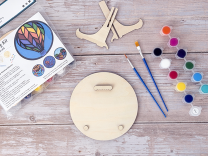 Back view of the Hot Air Balloon wood craft kit showing hanger piece, bumpers, paint pots, brushes, packaging, and stand.