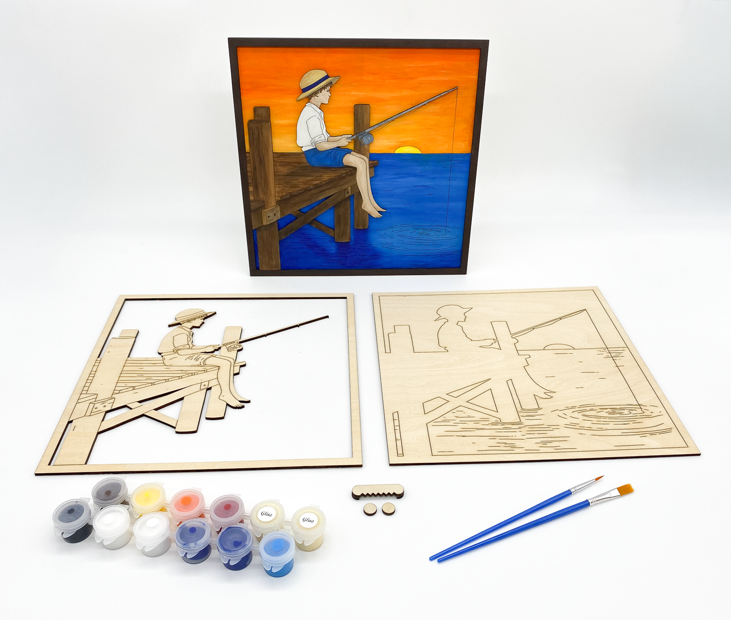 Wooden art project kit of boy fishing with paint supplies on a white background