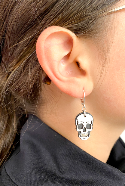Hand-painted layered wood skull earring worn on the ear to show size and style.