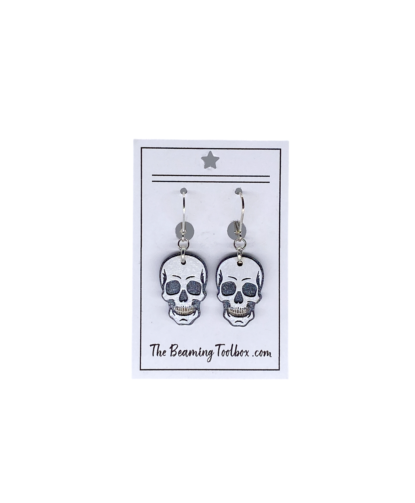 Hand-painted layered wood skull earrings on branded display card with silver-plated leverback hooks.