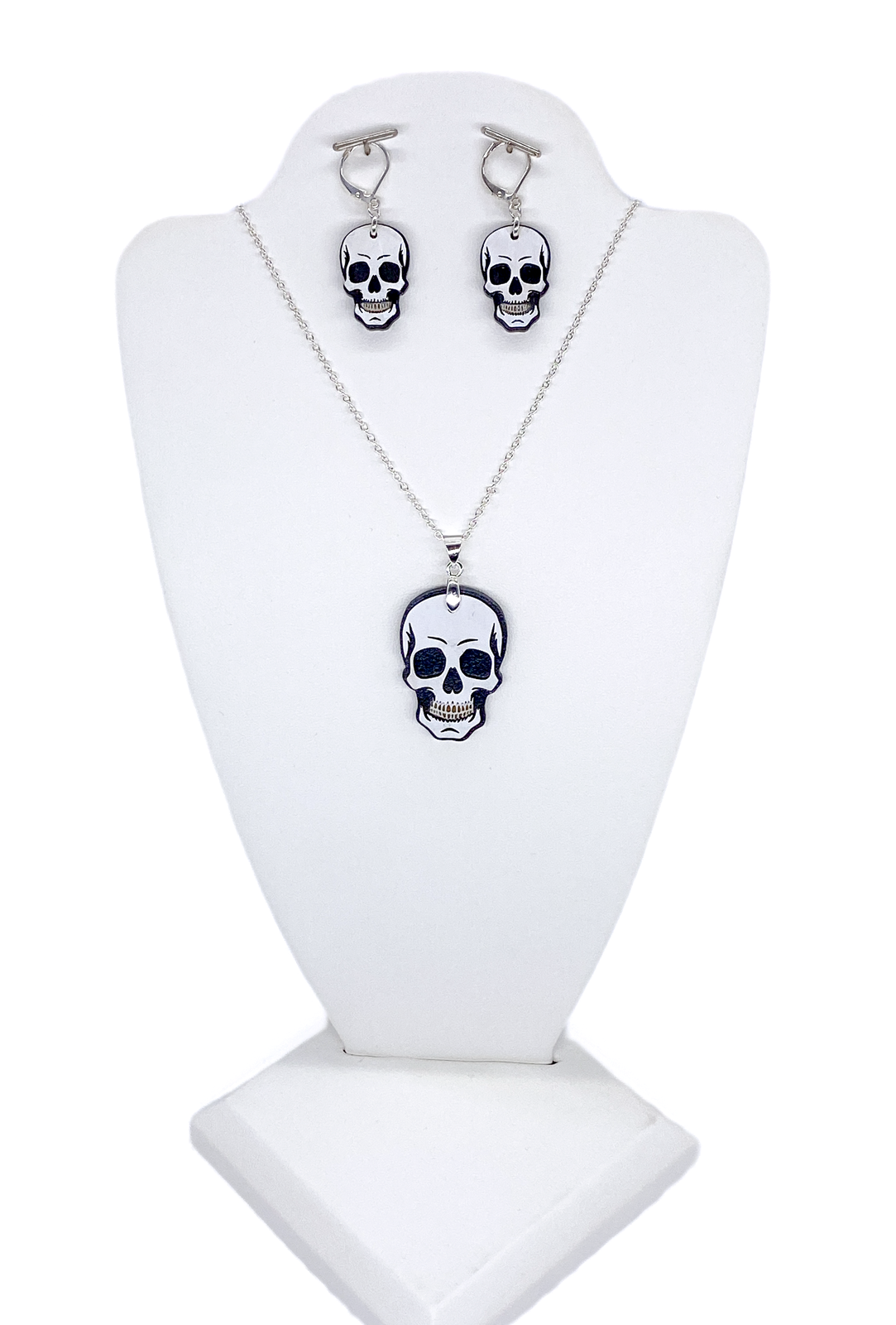 Layered wood skull necklace and matching earrings displayed on a white jewelry bust.