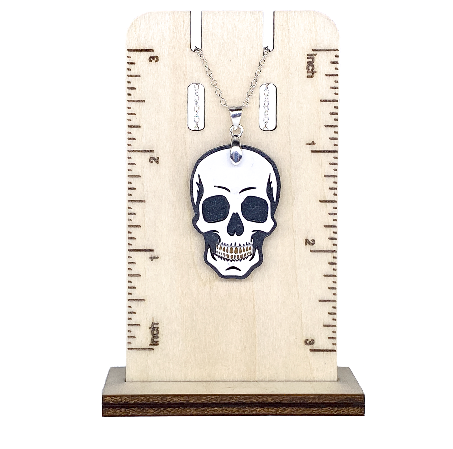 Layered wood skull necklace shown on a wooden ruler display for size reference.