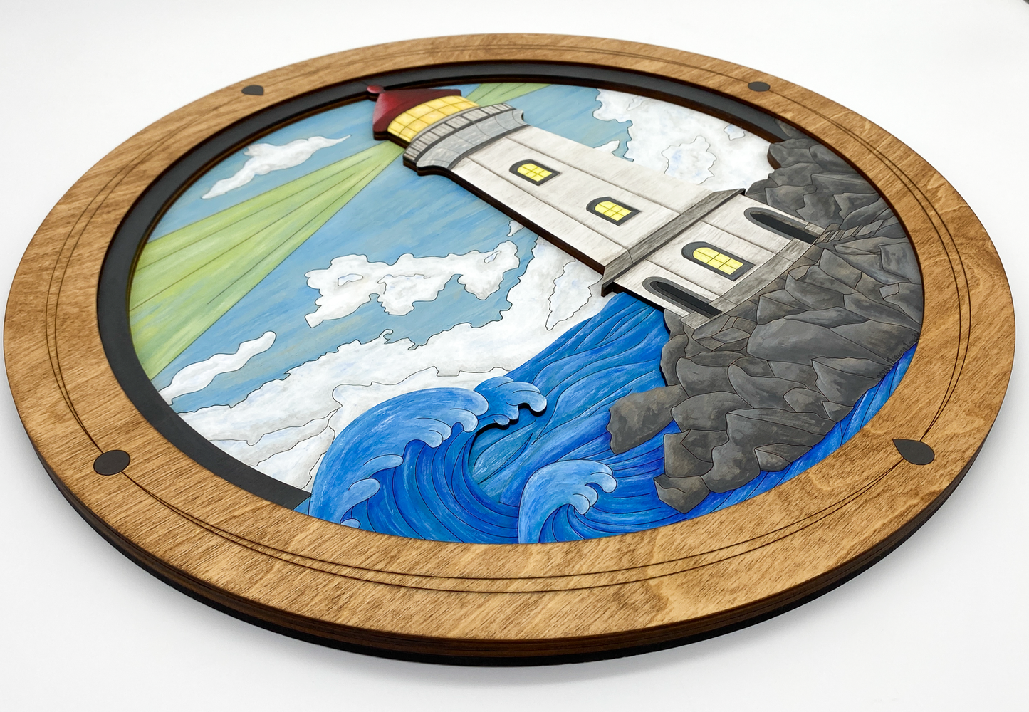 An angled view of "Lighthouse on a Rocky Shore" highlighting the 3D relief and the physical layers of the birch plywood ocean and rocks.