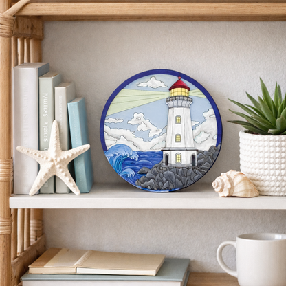 Front view of completed painted lighthouse layered wood art displayed on stand with ocean waves and light beam on display on a bookshelf with ocean theme