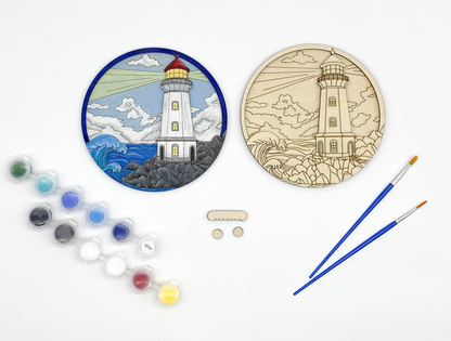 Lighthouse craft kit with unpainted wood layers stacked together alongside paint pots, brushes, and hanging hardware