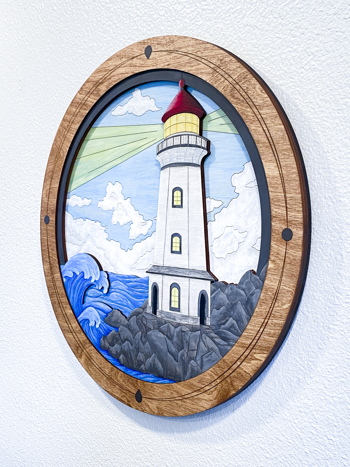 Decorative wall art of a lighthouse with a wooden frame on a light background