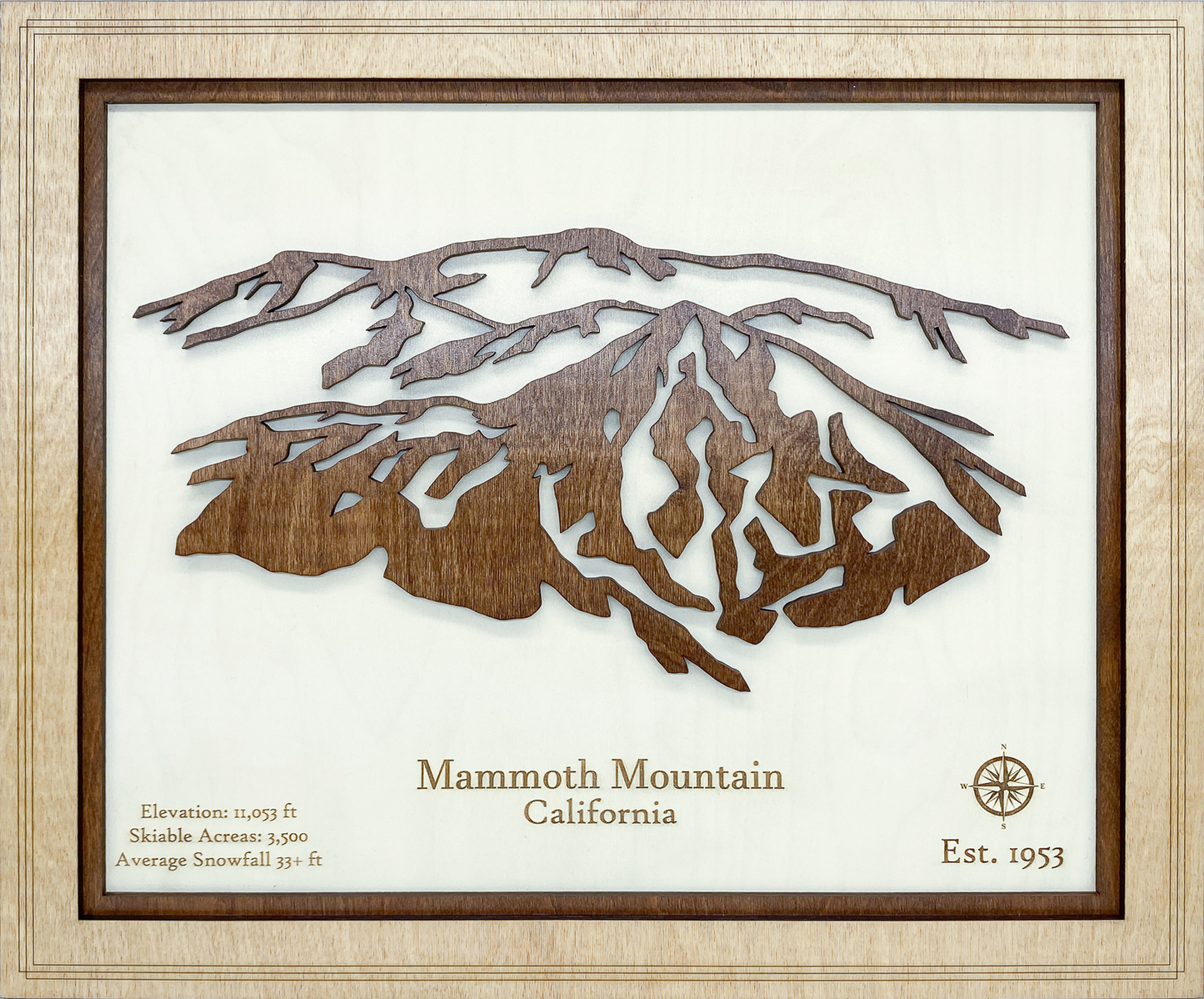 Wooden cutout of a mountain with text about Mammoth Mountain, California, framed in a light wood frame.