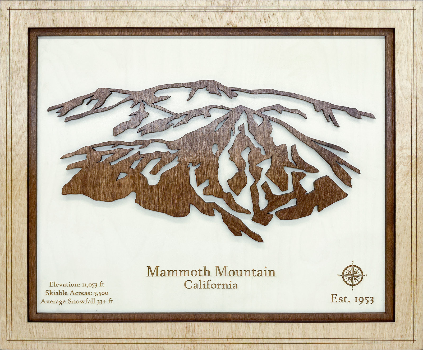 Wooden cutout of a mountain with text about Mammoth Mountain, California, framed in a light wood frame.