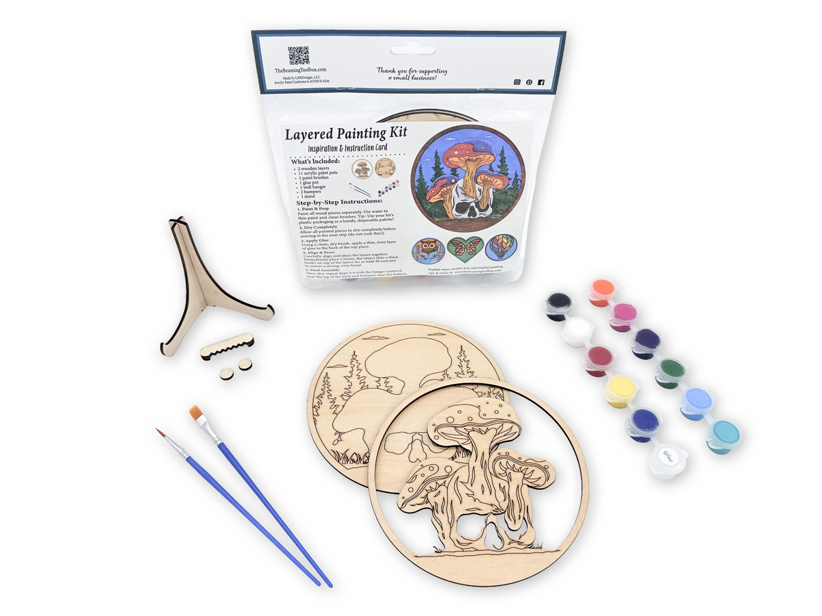 Complete Mushroom Skull adult craft kit with layered wood pieces, paint pots, brushes, glue, display stand, hardware, and packaged guide.