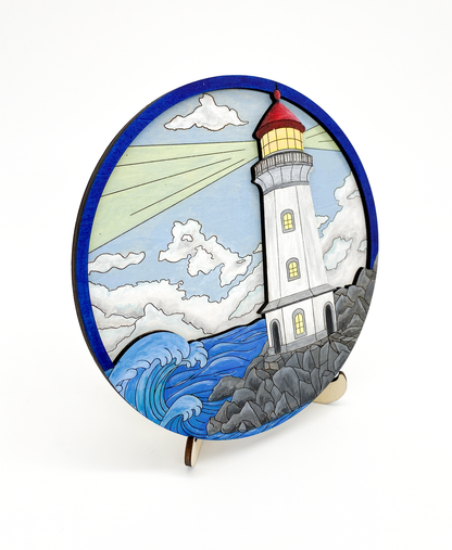 Side angle view of finished painted lighthouse layered wood art showing depth of layers and ocean scene