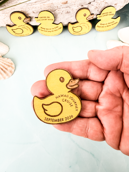 Hand holding a personalized wooden cruise duck token to show its small size and engraved cruise name and date.