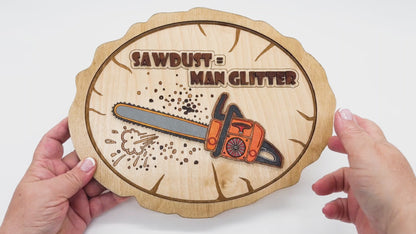 Video of Sawdust Equals Man Glitter showing the front and back with a colored chainsaw on front of a sign that is a faux wood round.