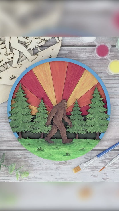 Video showing a Sasquatch layered wood adult craft kit being hand painted with bright acrylic colors on the engraved forest design.