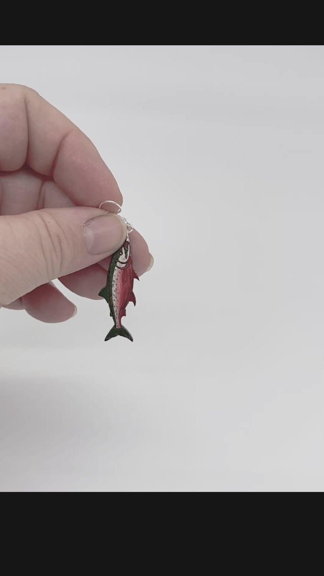 Video showing three styles of hand-painted wooden salmon earrings with green backs and silver plated hooks