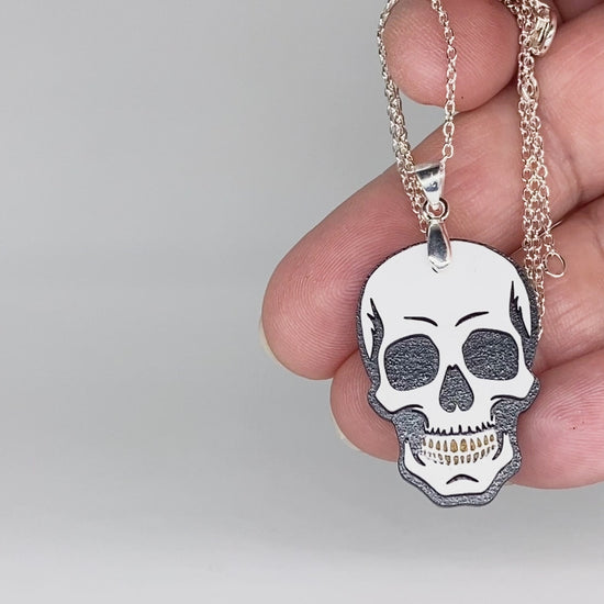 Video showing hand-painted layered wood skull necklace and earrings with close-up jewelry details.