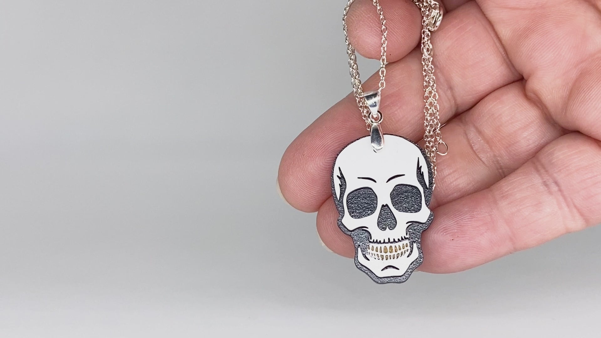 Video showing hand-painted layered wood skull necklace and earrings with close-up jewelry details.