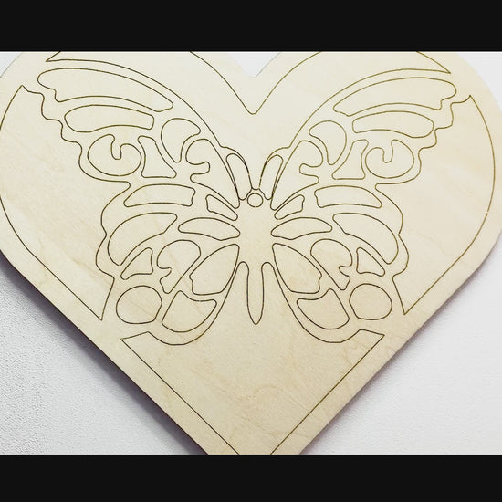 Sped up painting video of painting of a layered wood art kit of a monarch butterfly in a green colored heart.