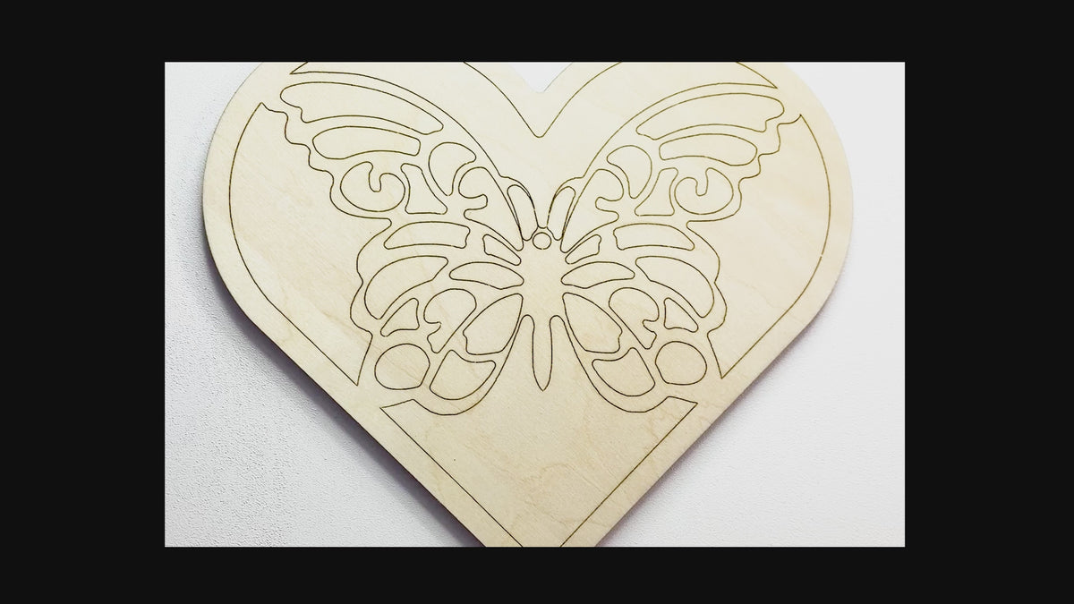 Sped up painting video of painting of a layered wood art kit of a monarch butterfly in a green colored heart.