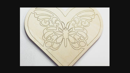 Sped up painting video of painting of a layered wood art kit of a monarch butterfly in a green colored heart.