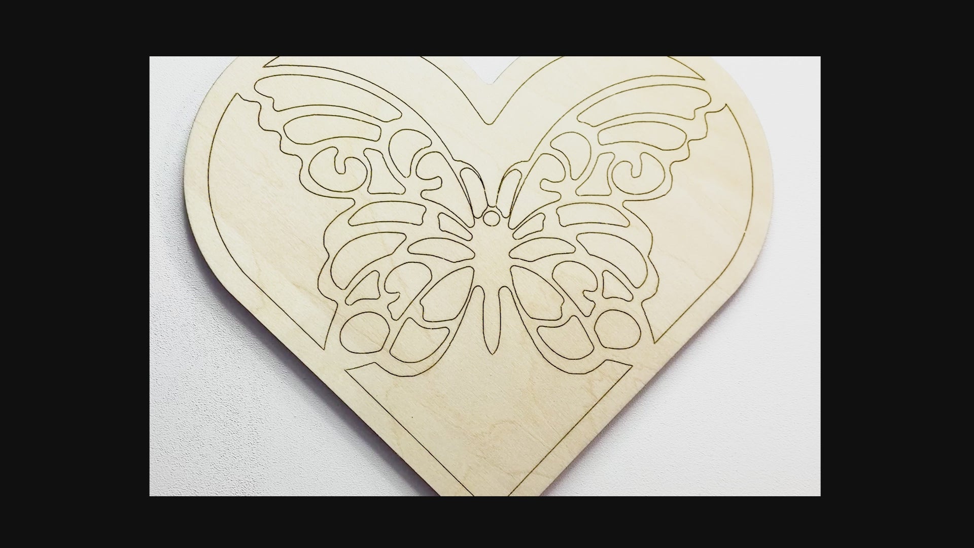 Sped up painting video of painting of a layered wood art kit of a monarch butterfly in a green colored heart.