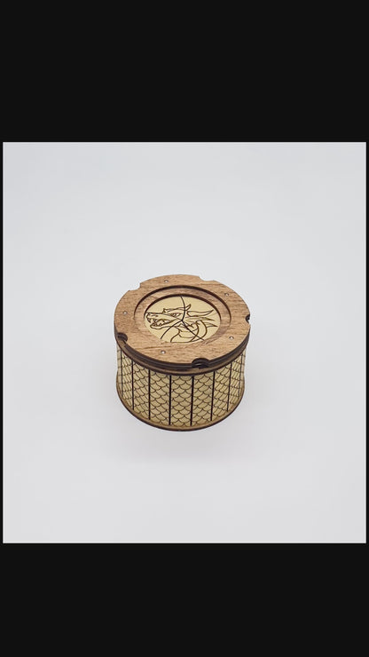 Video of opening and closing of wooden keepsake box with dragon engraved ontop of iris aperature top.  Inside has and engraved dragon's eye.  The outside is patterned with scales.