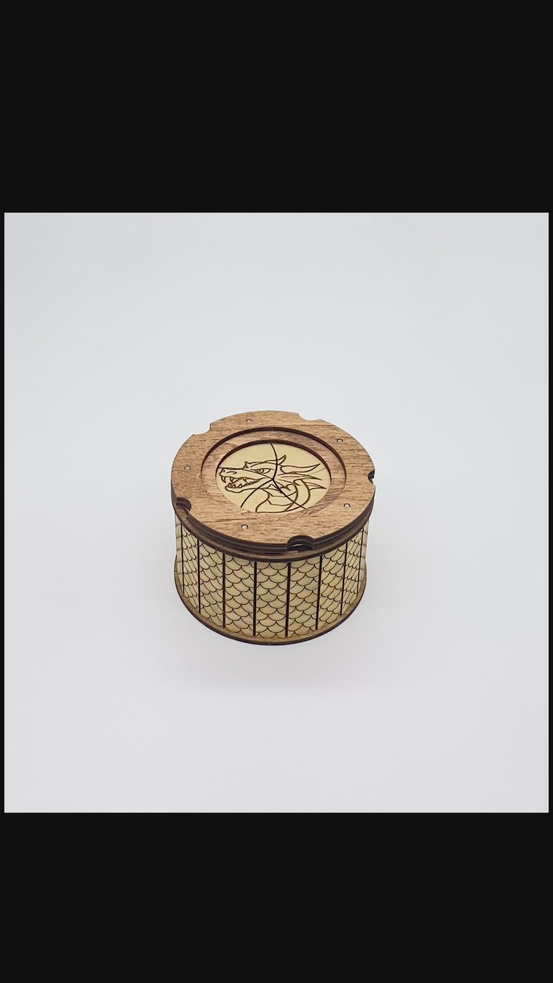 Video of opening and closing of wooden keepsake box with dragon engraved ontop of iris aperature top.  Inside has and engraved dragon's eye.  The outside is patterned with scales.