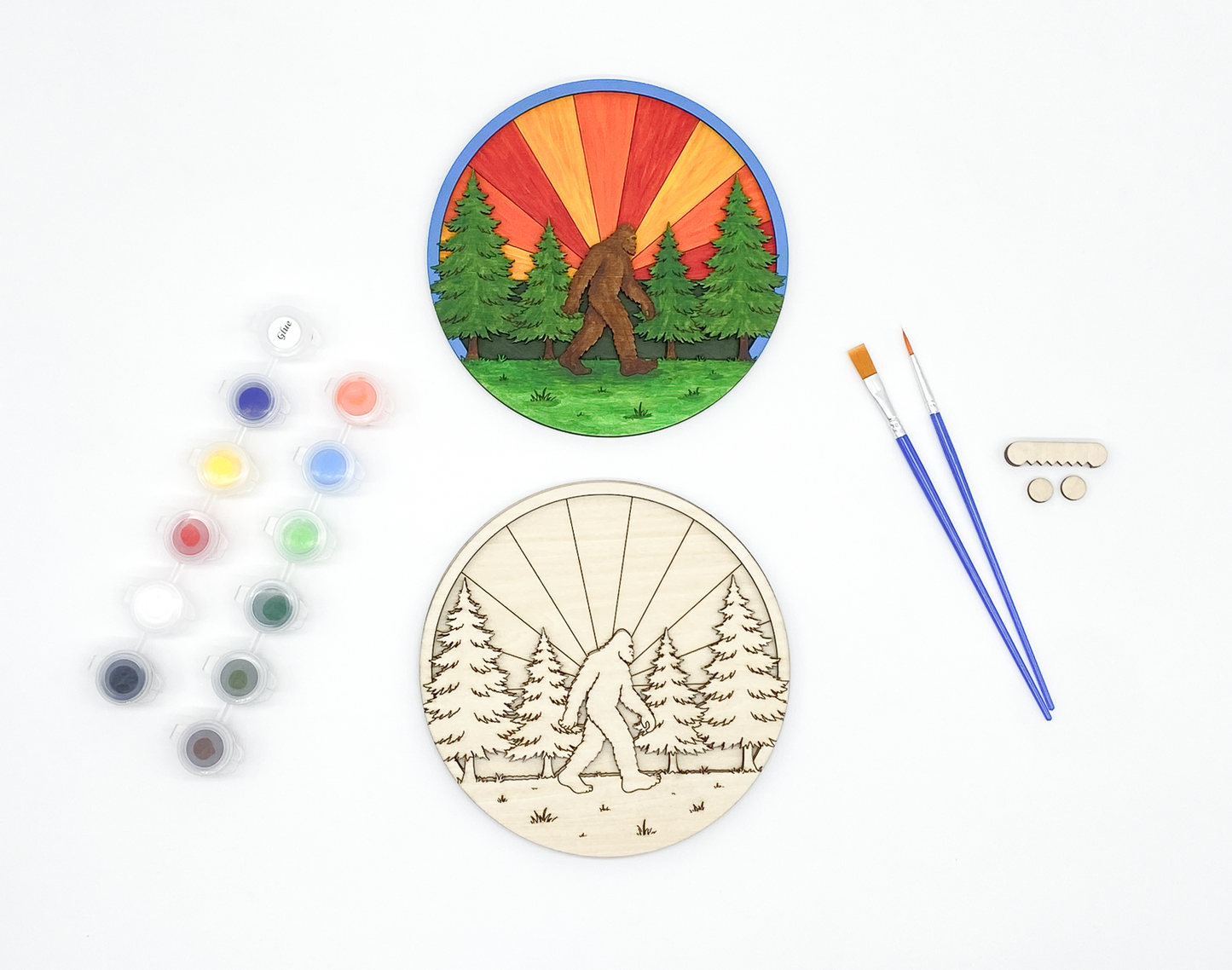 Unpainted Sasquatch wood kit layers stacked to show the 3D effect next to the finished colorful example and paint set