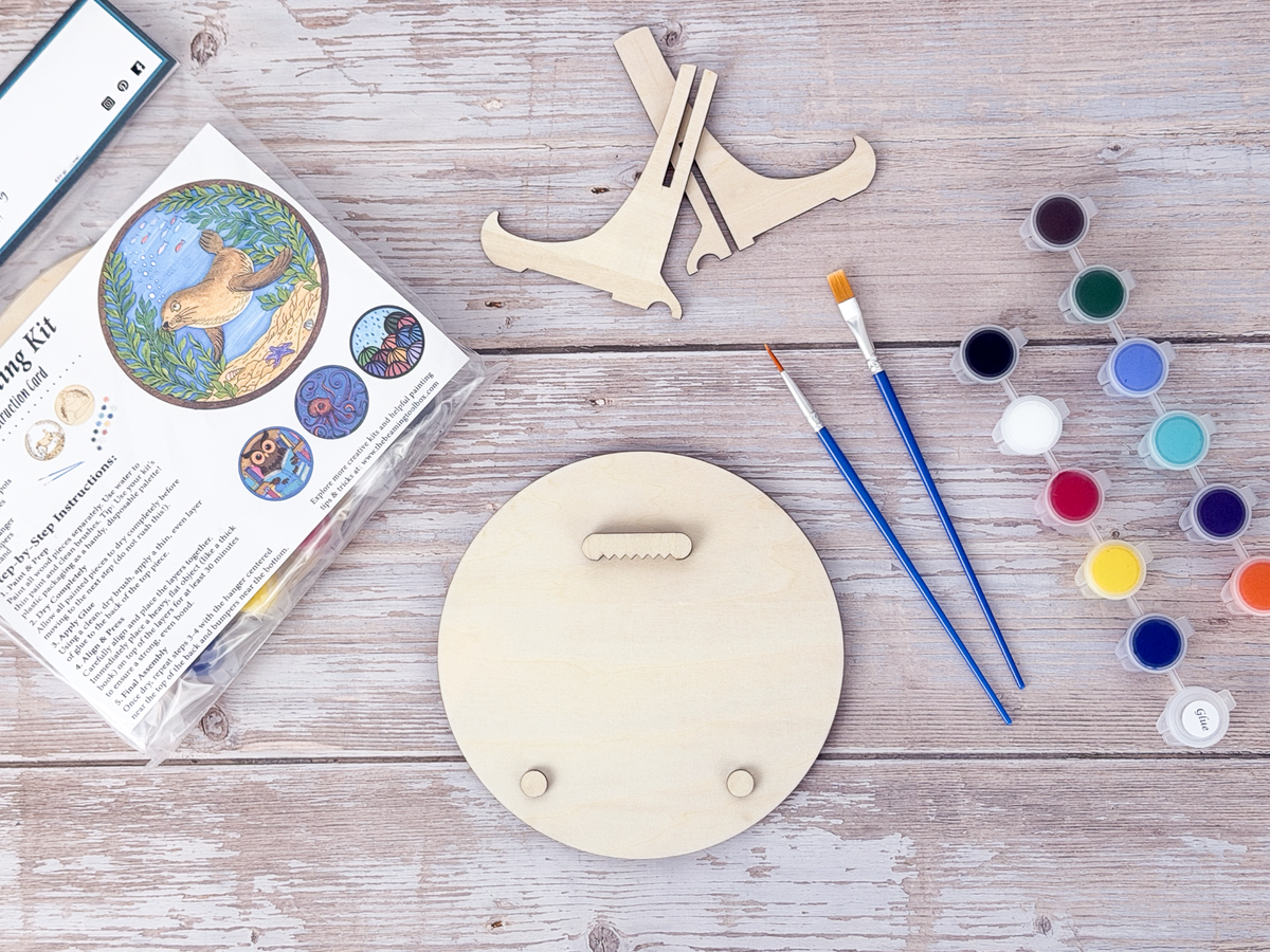 Sea Lion layered painting kit with unfinished wood pieces, paint pots, brushes, glue, display stand, hardware, and packaged guide.