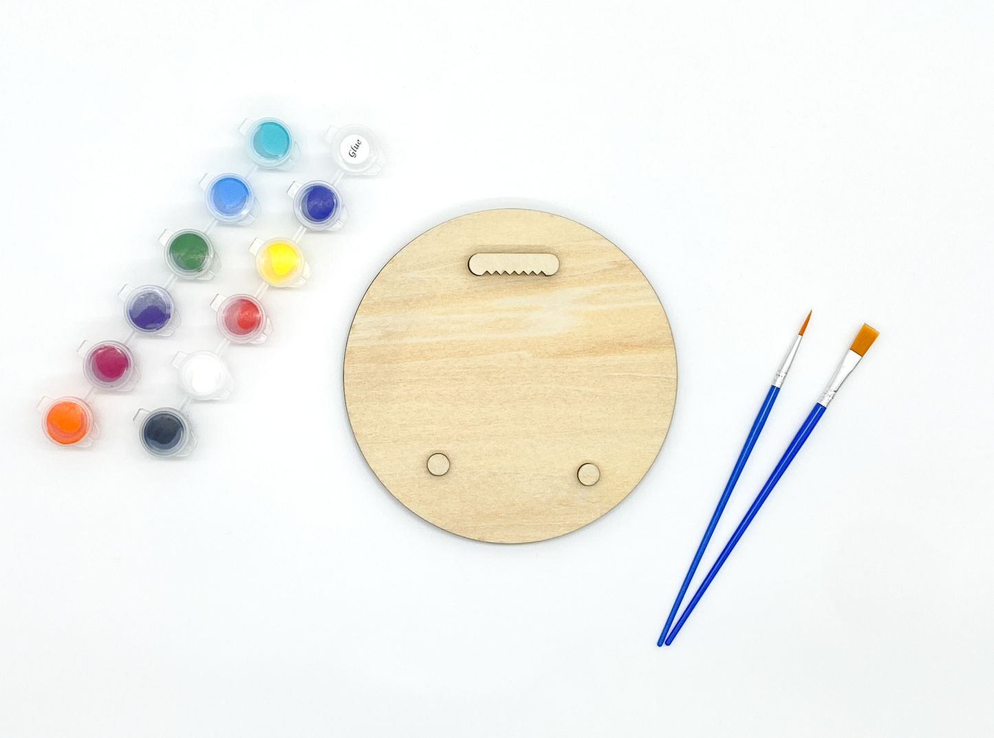 Back of sea lion wood art kit showing sawtooth hanger and bumpers installed with paint pots and brushes on white background