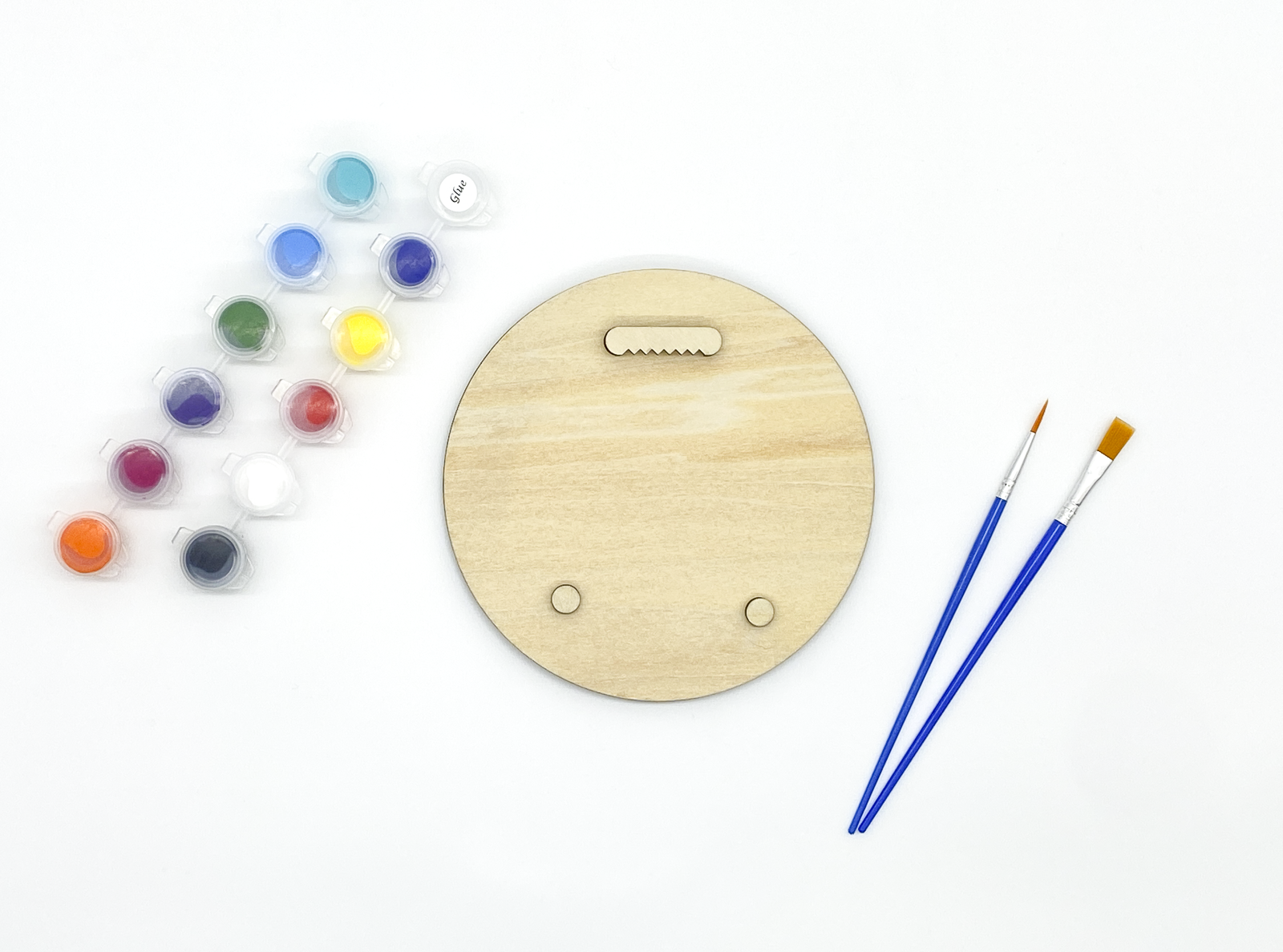 Back of sea lion wood art kit showing sawtooth hanger and bumpers installed with paint pots and brushes on white background