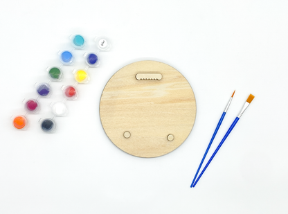 Back of sea lion wood art kit showing sawtooth hanger and bumpers installed with paint pots and brushes on white background