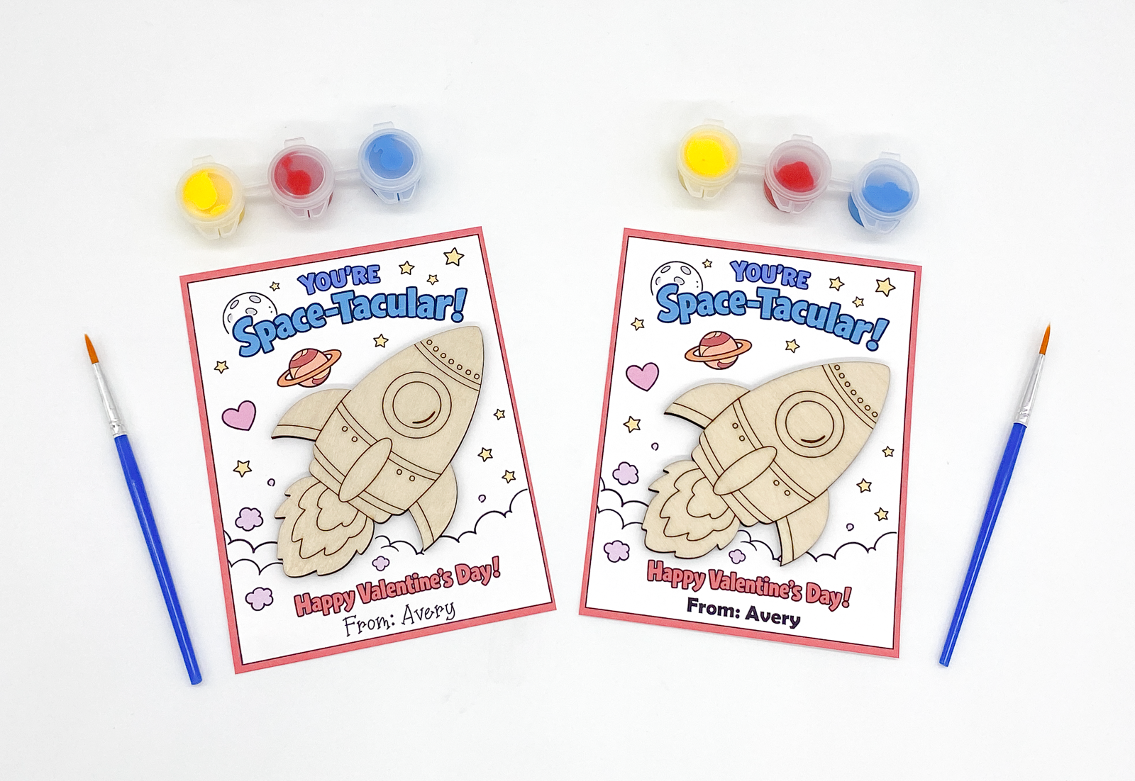 Two Valentine's Day cards with space-themed designs and coloring supplies on a white background.