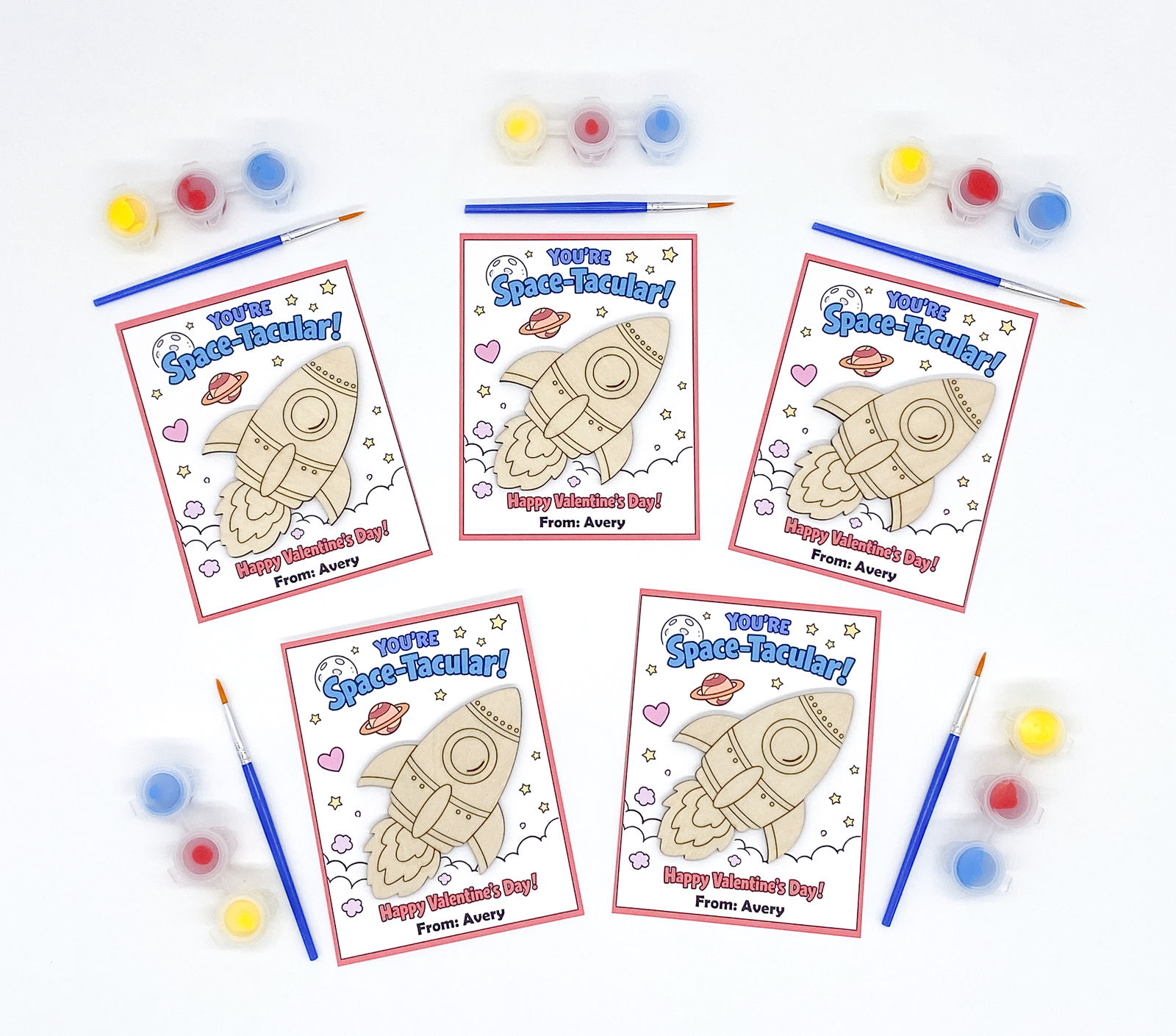 Five 'Space-Tacular' themed coloring pages with space-themed designs and text, surrounded by paint bottles and brushes on a white background.