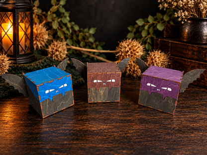 Blue, brown, and purple wooden bat trinket boxes arranged in a Halloween display, featuring hand-painted facial details, dark wings, and stained wood finishes.
