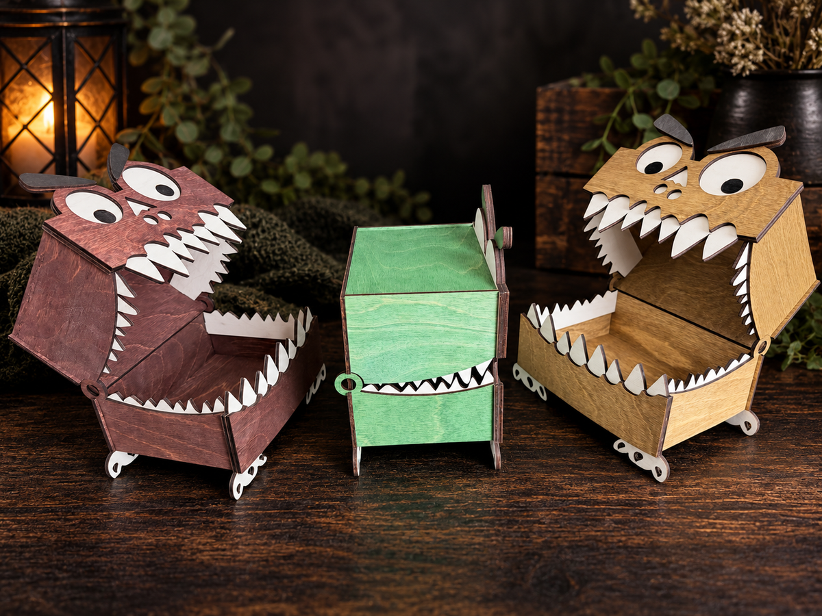 Two open wooden monster boxes in mahogany and walnut with white teeth and visible storage interiors, alongside a green monster box viewed from the side.